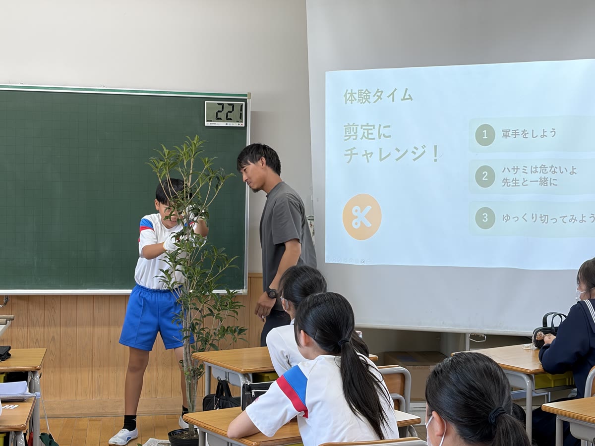 講師とともに植木の剪定を体験する国高小学校の児童