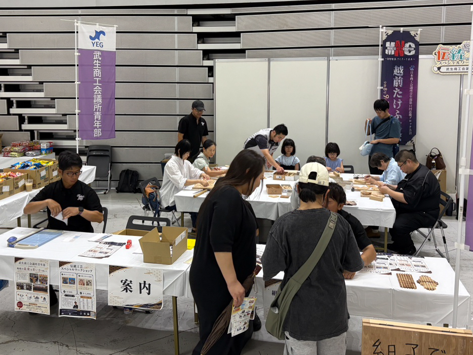 組子コースター作り体験と受付を行う武生YEGブース